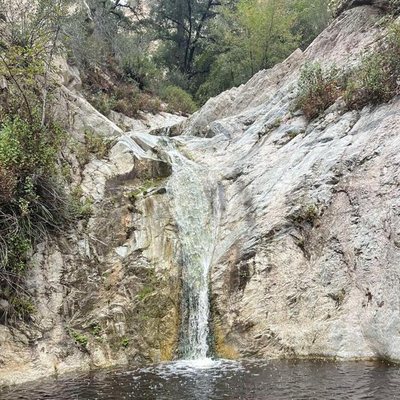 A waterfall tumbling over rocks into a still pool, photographed by Armando